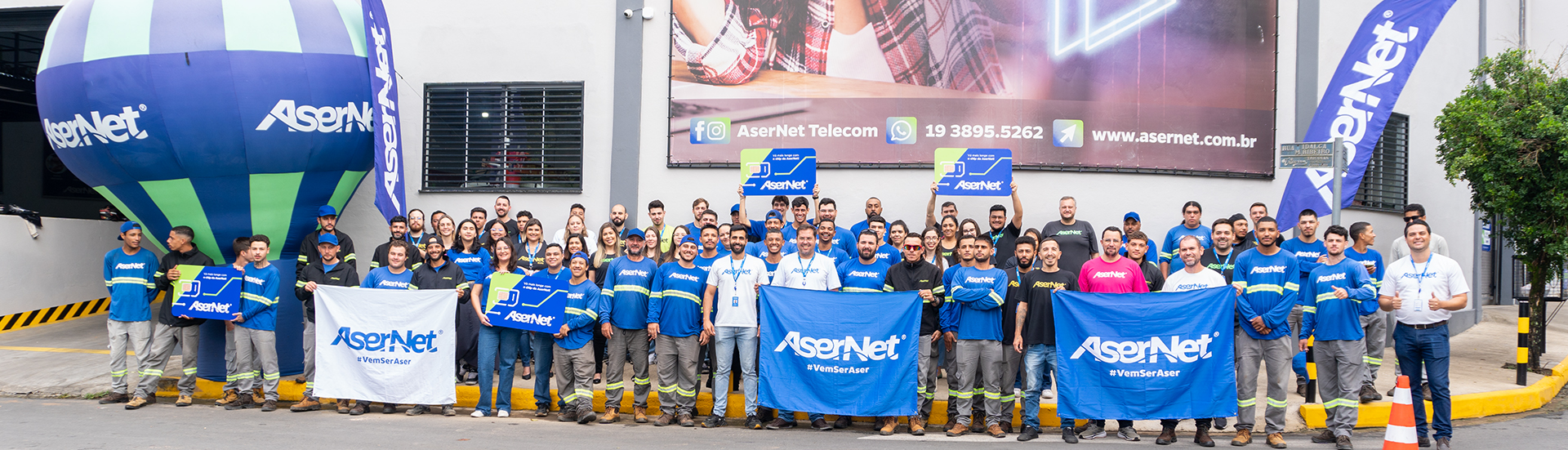 Imagem dos funcionarios da Asernet, com placas dizendo #VemSerAsernet.